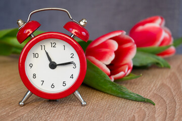 Alarm clock with fresh flowers. Spring summer time change