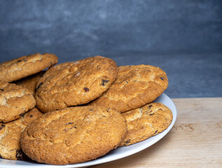 Oatmeal cookies in a plate.  Cookies with raisins on the table.