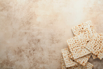 Passover celebration concept. Matzah, red kosher and walnut. Traditional ritual Jewish bread on sand color old concrete background. Passover food. Pesach Jewish holiday.