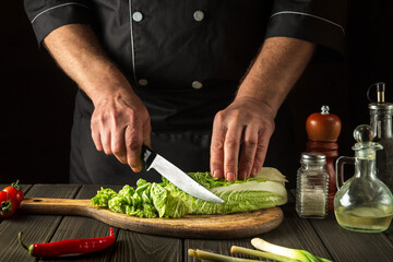 Chinese cabbage sliced on a cutting board in a restaurant kitchen. The head chef prepares a delicious salad for breakfast