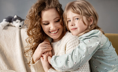 Cute little girl hug young caucasian mother. Smiling mom and small daughter embracing showing love...