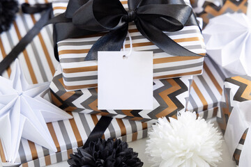 Wrapped present with blank square gift tag and black bow close up, label Mockup