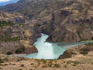 The confluence of the Baker river (with bright turquoise waters) with the Neff river (with greyish...