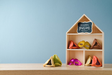 Jewish holiday Purim celebration background with colorful hamantaschen cookies and toy house on...