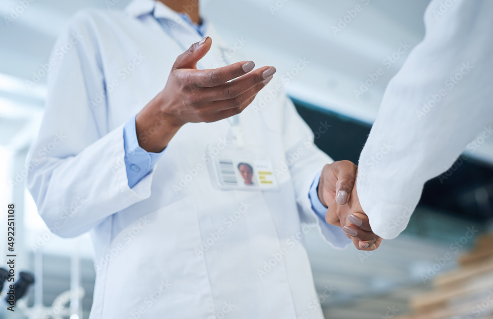 Poster The biggest deal in research and development. Shot of two unrecognisable scientists shaking hands in a laboratory.