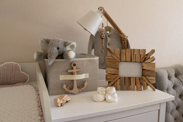 baby changing table with empty photo frame, lamp, socks and toys