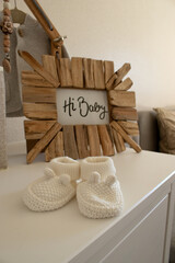Plakat photo frame, with baby socks on white table