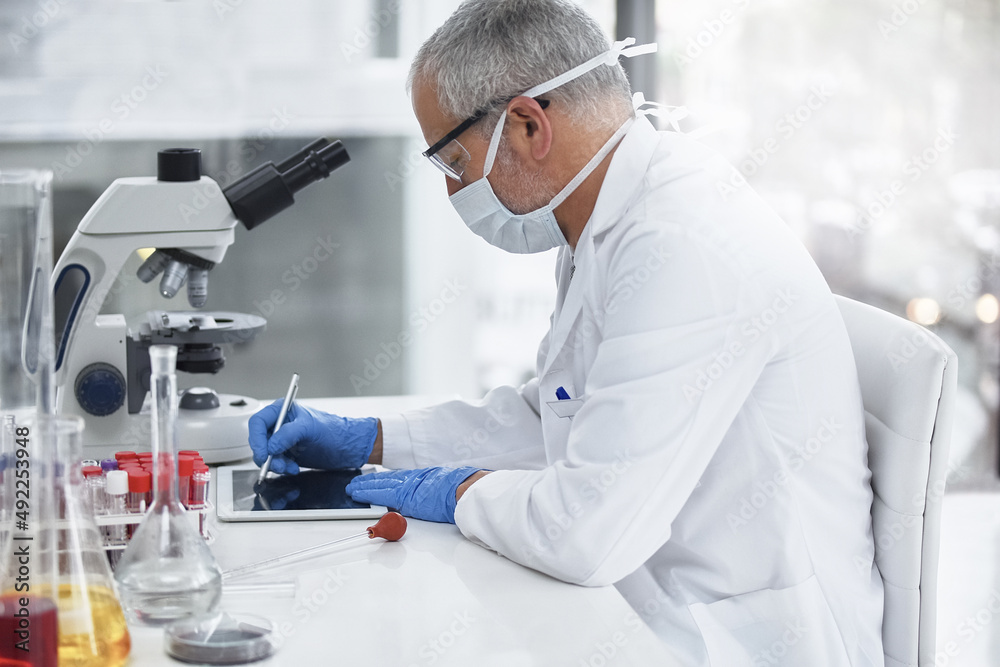 Wall mural Dillingent in his research. Shot of a researcher at work on a microscope in a lab.