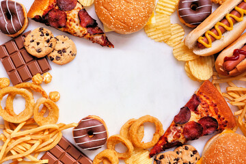 Junk food frame over a white marble background. Variety of take out and fast foods. Pizza,...