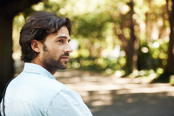 In the comfort of nature. Shot of a handsome young man in the park.