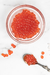 Salmon Red Caviar. Red fish caviar on a spoon in glass bowl. Raw seafood. Luxury delicacy food. appetizer, selective focus, place for text