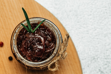 Red onion marmalade jam confiture in jar. Vegetable jam on dark background. Delicious sauce. French cuisine. Food recipe background. space for text