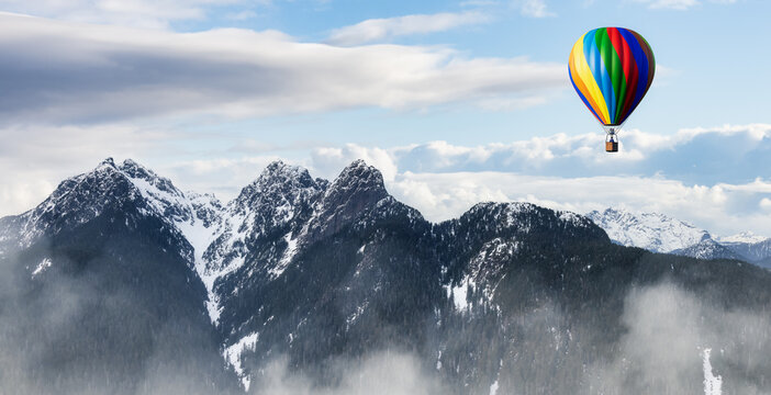 Dramatic Mountain Landscape covered in clouds and Hot Air Balloon Flying. 3d Rendering Adventure Dream Concept Artwork. Aerial Image from British Columbia, Canada. Colorful Blue Sky
