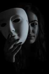 Being authentic and true concept - Black and white portrait of a beautiful young woman with long hair taking off her mask
