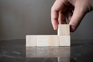 Hand choosing a wooden block from a set. Business choice concept