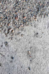 Sand and gravel on concrete floor, background texture.