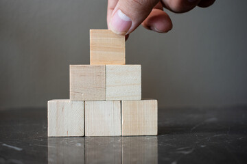 Hand holding blank wooden block cubes