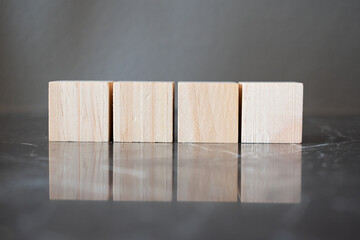 Tower of four wooden cubes on neutral background with copy space