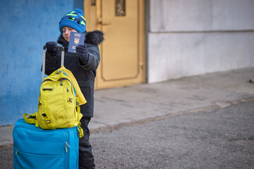 Evacuation of civilians, sad child with the flag of Ukraine. Refugee family from Ukraine crossing...