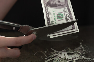 the concept of inflation in America, cut off a piece of 100 dollar bill, depreciation of money