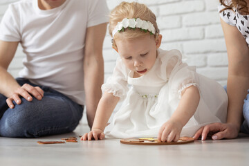 Naklejka premium Baby child with hearing aids and cochlear implants plays with parents on floor. Deaf and rehabilitation concept
