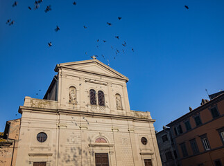 The village of Tarquinia, Viterbo, Lazio, Italy - The facade of the church of Saints Margherita and Martino. The mullioned window in the center and the two niches with the statues of the saints.
