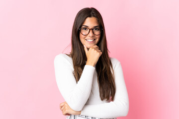 Young brazilian woman isolated on pink background happy and smiling