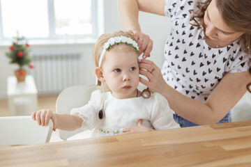 Mother helps to put on cochlear implant for her deaf little daughter. Hearing aid and deafness concept