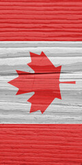 Canadian flag on a dry wooden surface. Natural background. Vertical backdrop made of old wood. The...