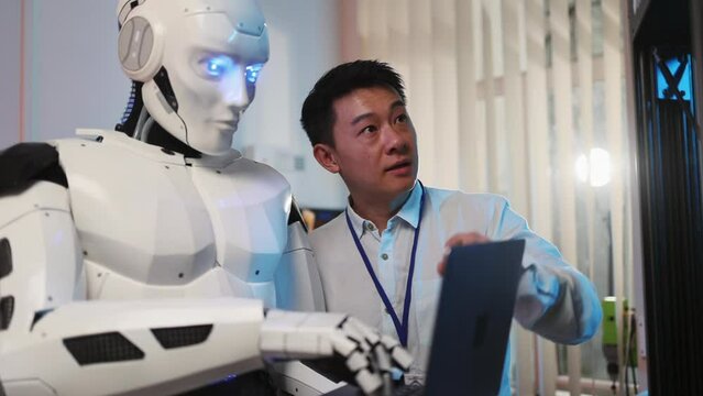 Asian engineer with AI robot learning 3d printing technology using computer laptop to control three dimensional printer. Future concept. Laboratory.