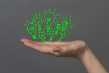 Hands holding green nature in the light bulb