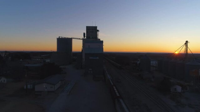 Sunrise aerial of grain elevator and binds in small midwestern town