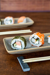Sushi set on plates. Sushi uramaki and nigiri with salmon fish and surimi sticks food.