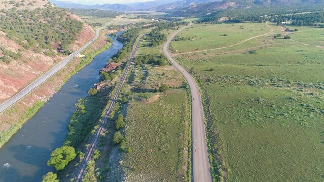 Runners on a mountain road by a river, aerial view in USA