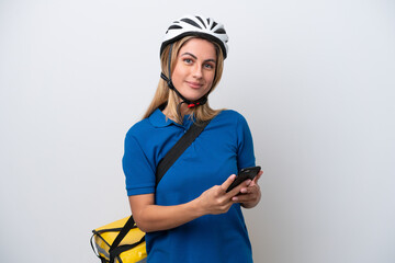Young caucasian woman with thermal backpack isolated on white background sending a message with the mobile