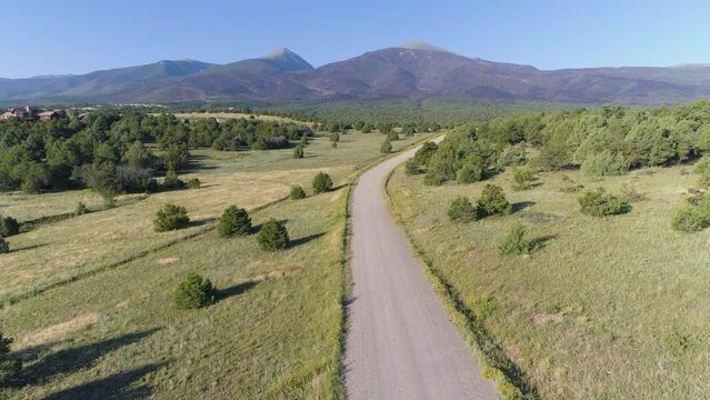 Aerial of woman running on rural mountain road in USA