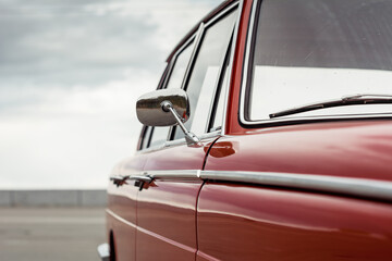 Red classic car. Sedan from 1960s with chrome mirror - obrazy, fototapety, plakaty