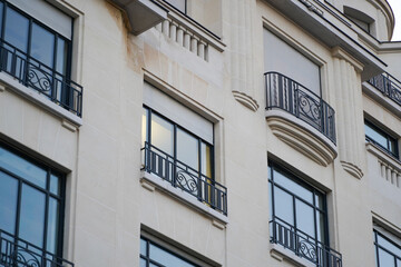 Naklejka premium Beautiful facade of a building from Paris, France, with a lot of plants and elegant architecture details and decorations.