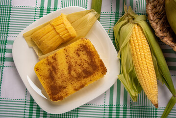 Brazilian Cural, candy corn and pamonha, corn on the cob arranged on a table with a green and white...