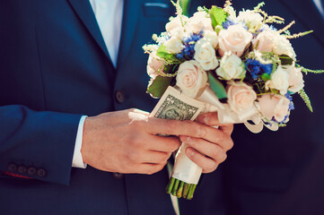 Elegant wedding bouquet in groom hand, beautifully decorated flowers closeup