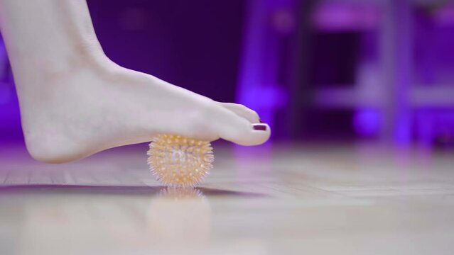 Healthy female foot arch massage therapy with spike ball 4K