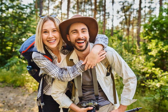 Laughing couple hiking in the woods posing for a photo