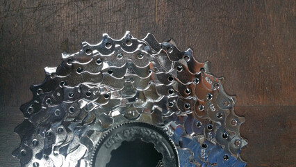 photo bicycle parts - bicycle chrome cassette sprockets - close up on a dark wood background