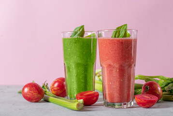 Vegetable smoothies from celery and tomatoes, in two tall glasses on a pink background, healthy diet cold drinks