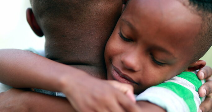 Son hugging father. African kid embracing dad, candid authentic love