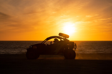 Buggy running at the beach at sunset