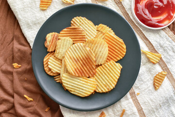 Crisps or Potato chips on a black plate. Flat lay top view food photo. Food from above concept.