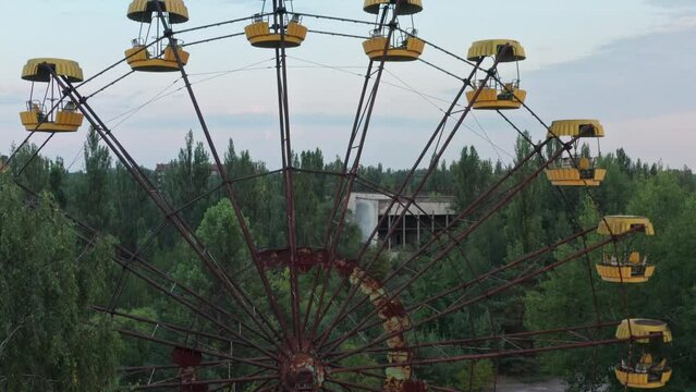 Pripyat through the abandoned ferris wheel . View on Chernobyl Nuclear Power Plant. Destroyed buildings. Chernobyl Video from the drone. High quality 4k footage