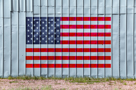 american flag painted metal warehouse farm steel building wall faded weathered america pride holiday patriotism symbol