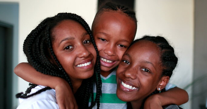 Little brother and steen sisters embrace. Black African ethnicity children